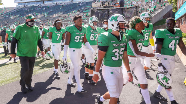 Marshall football players walk to the tunnel